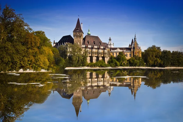 Palazzo storico a Budapest - Castello di Vajdahunyad con lago sopra il cielo blu nel parco principale della città. Questo è il castello simile come in Transilvania — Foto Stock