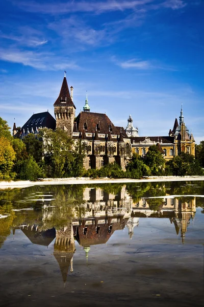 Historisk byggnad i budapest - vajdahunyad castle med sjö över den blå himlen i stadens park. Detta är det liknande slottet som i transilvania Stockbild