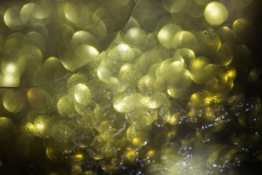 Parlak bulanık halkalar üzerinde sıvı bulunan soyut arkaplan, kapat.