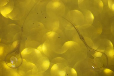 Parlak bulanık halkalar üzerinde sıvı bulunan soyut arkaplan, kapat.