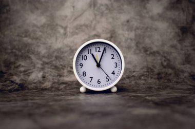 white alarm clock on marble background Time concept and setting an alarm