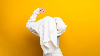 Beyaz kazak giyen Asyalı kadınlar onun uzun kollu beyaz gömleğini giyiyor.