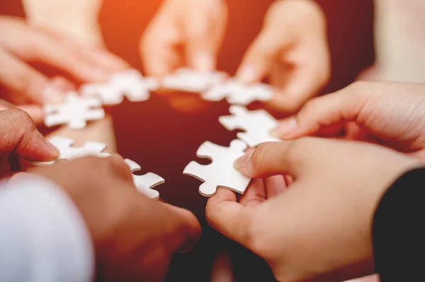 Close-up of businessman with puzzle pieces in office teamwork unity in teamwork The concept of combining strength and power