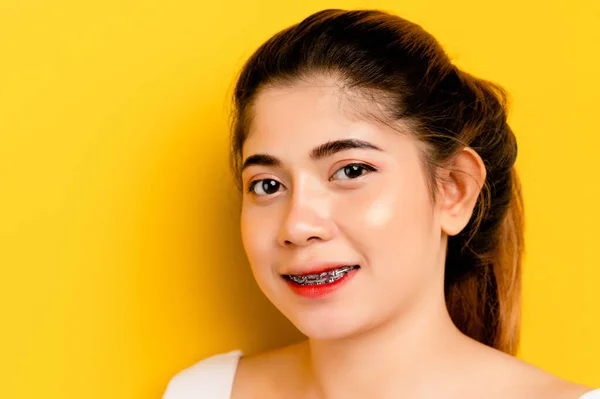 Smiling woman. Close-up of a cute girl wearing a white dress. on a yellow background