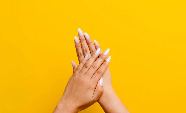 Twee Schone Witte Handen Mooie Nagels Verstrengeld Een Gele Achtergrond — Stockfoto