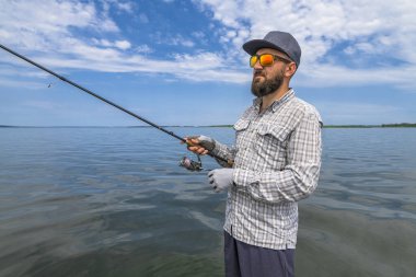 Dönen balık avı. Sakallı balıkçı, balık grevi ısırığını bekliyor.