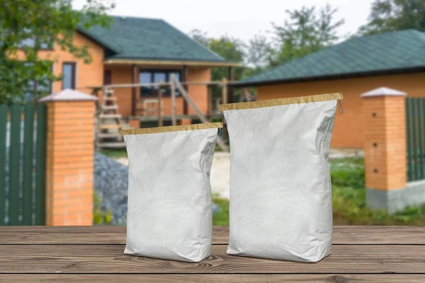 Paper bags on boards. Plaster cement sacks on blurred background of house construction