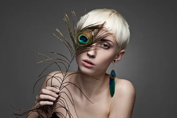 Girl holding peacock feather — Stock Photo, Image