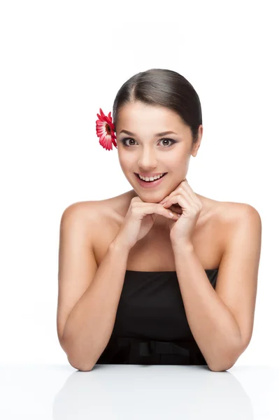 Young brunette female with gerbrera flower in hair — Stock Photo, Image