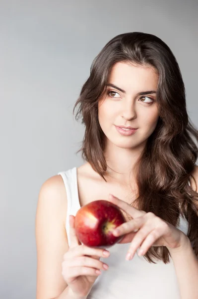 Thoughtfull young casual caucasian girl with red apple — Stock Photo, Image