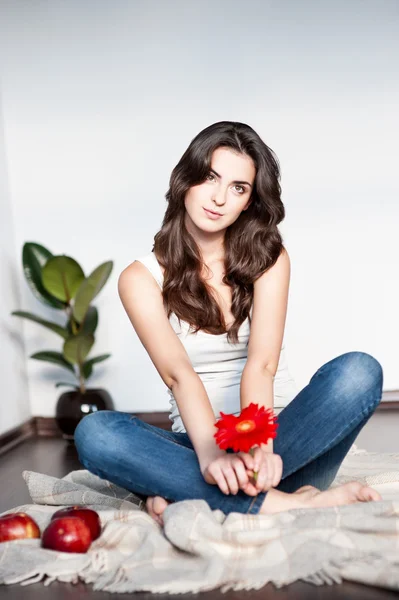 Thoughtful young casual female with red flower — Stock Photo, Image