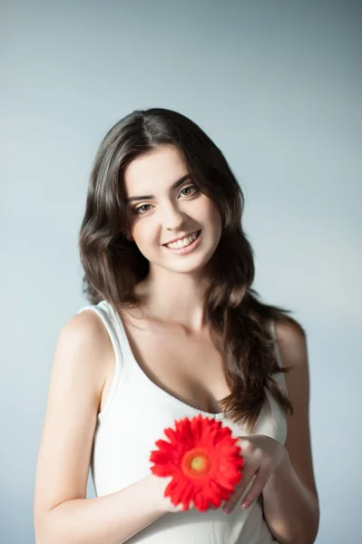 Genç gülümseyen casual beyaz kız kırmızı çiçek — Stok fotoğraf