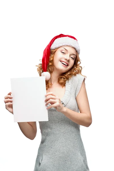 Young casual girl in santa hat holding sign — Stock Photo, Image