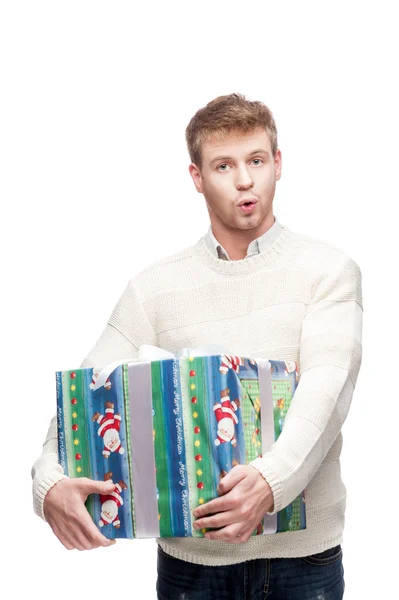 Young surprised man holding big heavy gift — Stock Photo, Image