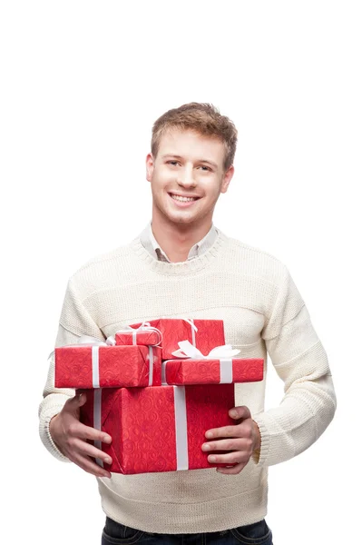 Young man holding many red christmas gifts — Stock Photo, Image