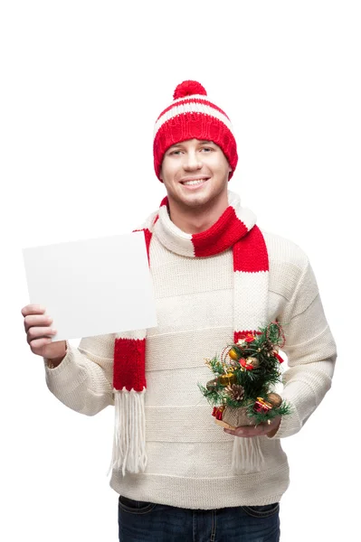 Joven sosteniendo pequeño árbol de navidad y signo —  Fotos de Stock