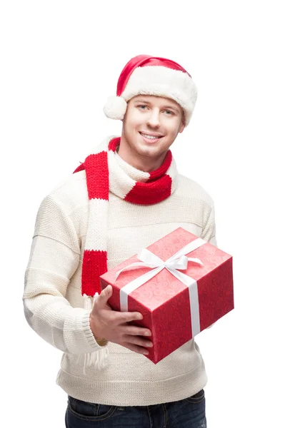 Young man in santa hat holding big red christmas gift — Stock Photo, Image