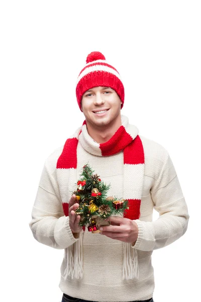 小さなクリスマス ツリーを保持している若い男 — ストック写真