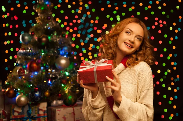 Jovem sorrindo mulher segurando vermelho presente de Natal — Fotografia de Stock