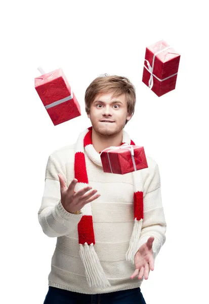 Young funny man juggle the christmas gifts — Stock Photo, Image