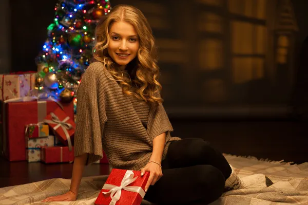 Junge lächelnde Frau mit rotem Weihnachtsgeschenk — Stockfoto