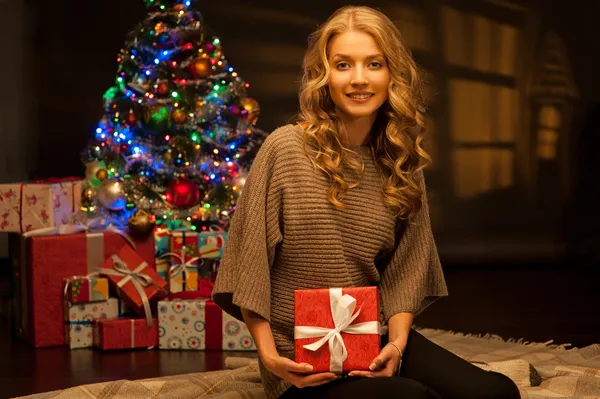 Junge lächelnde Frau mit rotem Weihnachtsgeschenk — Stockfoto