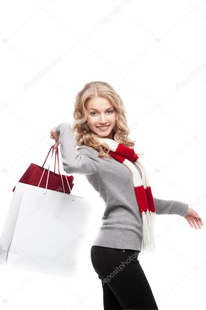 Young cheerful woman holding shopping bags