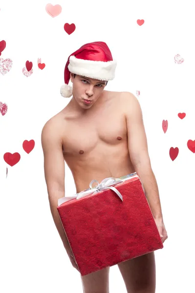 Naked man in santa hat holding christmas gift — Stock Photo, Image