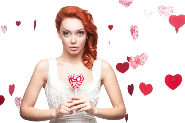 Surprised red-haired woman holding lollipop — Stock Photo, Image