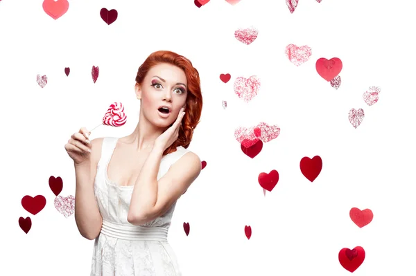 Surprised red-haired woman holding lollipop — Stock Photo, Image