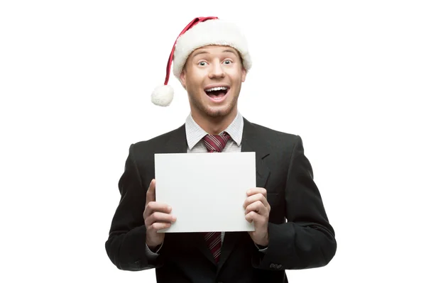 Young funny businessman in santa hat holding sign — Stock Photo, Image