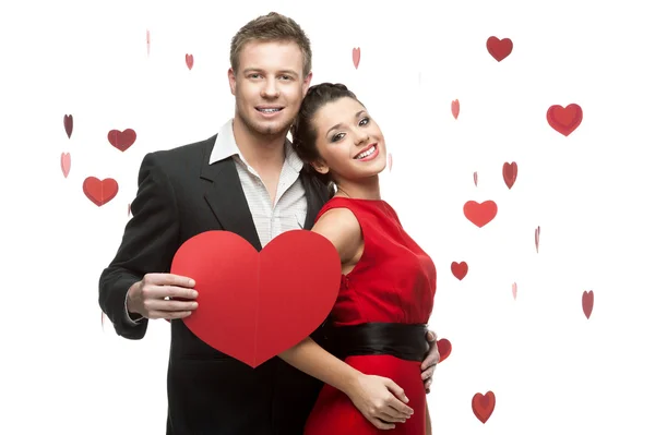 Young couple holding sign in form of red heart — Stock Photo, Image