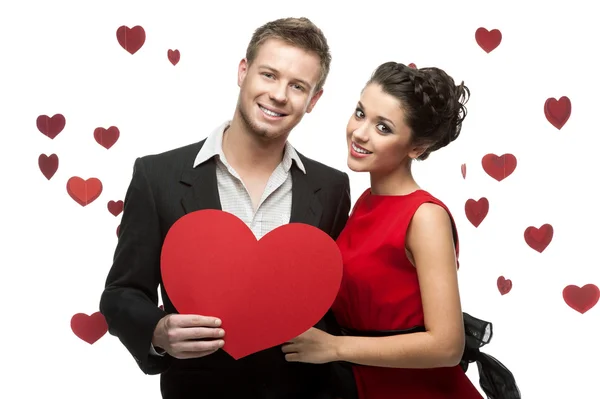 Молодая пара держит знак в виде красного сердца — стоковое фото