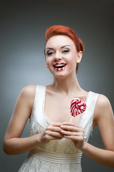 Happy red-haired girl holding candy — Stock Photo, Image