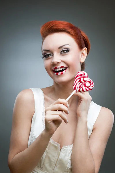 Feliz chica pelirroja sosteniendo caramelos — Foto de Stock