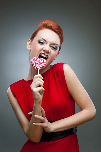 Divertente ragazza dai capelli rossi in possesso di caramelle — Foto Stock