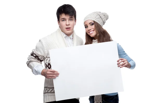 Young smiling winter couple holding big sign — Stock Photo, Image