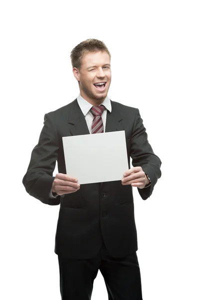 Junger augenzwinkernder Geschäftsmann hält Schild — Stockfoto