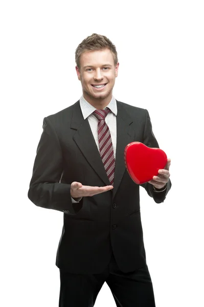 Young cheerful businessman holding red heart — Stock Photo, Image