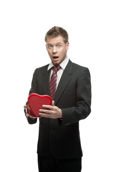 Young surprised businessman holding red heart — Stock Photo, Image