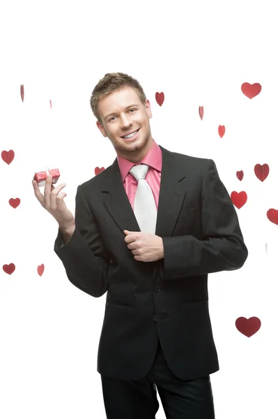 Young cheerful businessman holding red gift — Stock Photo, Image