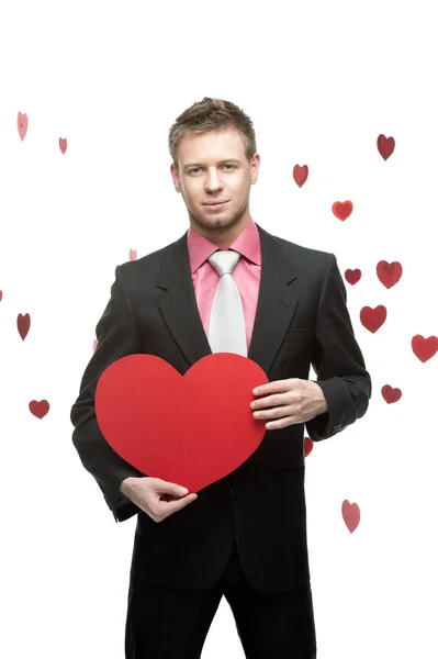 Young smiling businessman holding big red heart — Stock Photo, Image