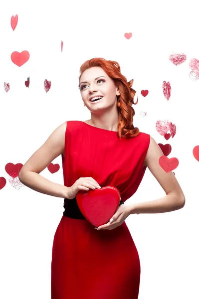 Smiling red-haired girl holding red heart — Stock Photo, Image