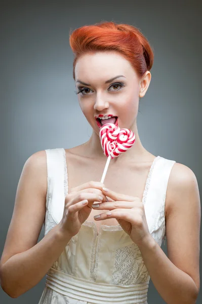 Happy red-haired girl holding candy — Stock Photo, Image