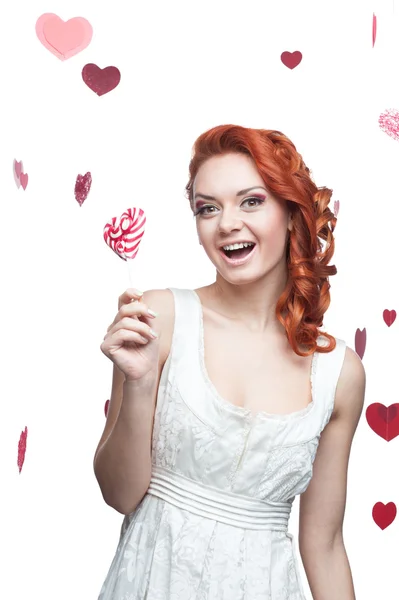 Surprised red-haired woman holding lollipop — Stock Photo, Image