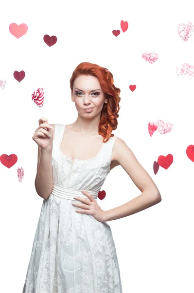 Surprised red-haired woman holding lollipop — Stock Photo, Image