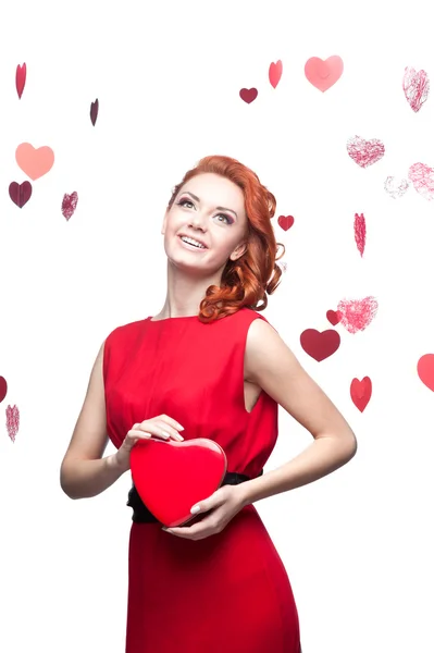 Улыбающаяся рыжая девушка с красным сердцем — стоковое фото
