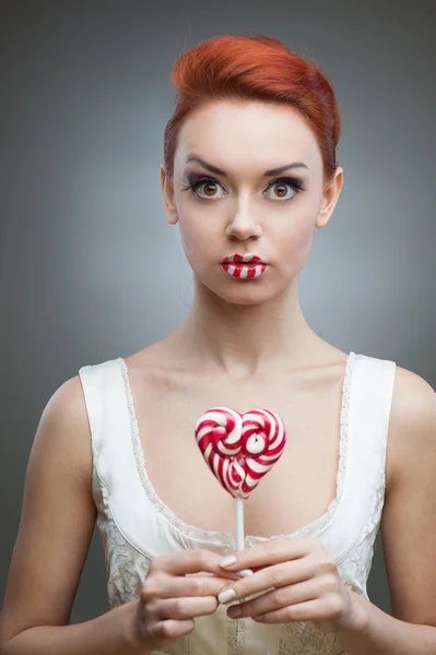 Menina de cabelos vermelhos segurando doces — Fotografia de Stock