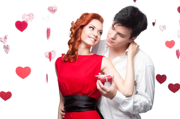 Young smiling couple holding small red gift — Stock Photo, Image