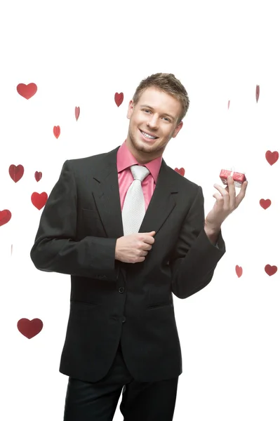 Young cheerful businessman holding red gift — Stock Photo, Image